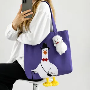 Detail of purple canvas duck tote bag with 3D yellow webbed feet and plush sheep charm