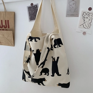 Close-up of cream canvas tote bag with cute black bear prints and soft double handles