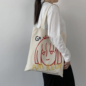 Detailed view of canvas tote bag with artistic cartoon print and sturdy shoulder strap