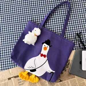 Detail of purple canvas tote bag with cartoon duck print and 3D plush feet decoration
