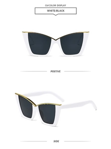 Detail view of white cat-eye sunglasses with gold metal trim and dark lenses