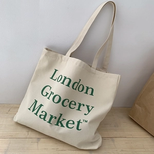 Detailed close-up of cream canvas tote bag with green London Grocery Market text