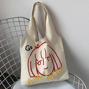 Detail of off-white canvas tote bag with red minimalist girl illustration and lettering