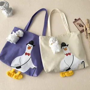 Detail of cute duck canvas tote bags in purple and beige with 3D plush feet and charms