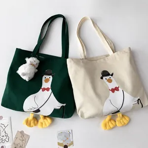 Detail of cute duck canvas tote bags with 3D feet and cartoon goose prints in green and white