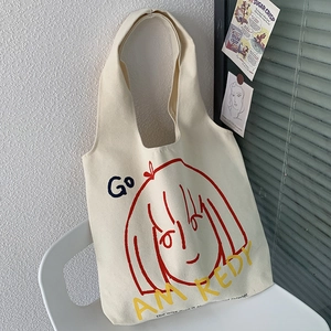Detail of artistic canvas tote bag featuring graphic illustration and motivational text