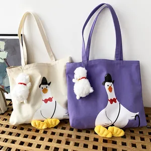Detail of canvas tote bags with goose illustration and plush duck feet accessories