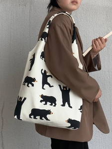 Detail of canvas tote bag showing black bear print and large capacity for students