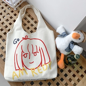 Close-up of cream canvas tote bag with red line girl art and bold artistic typography