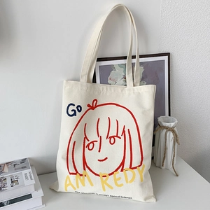 Detail of canvas tote bag with artistic girl illustration and motivational slogans