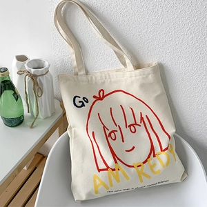 Detail of artistic canvas tote bag with red line girl illustration and text on a chair