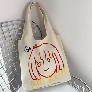 Detail of artistic canvas tote bag with red portrait illustration on a silver wire chair