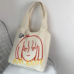 Artistic canvas tote bag with red portrait print on a white metal chair scene