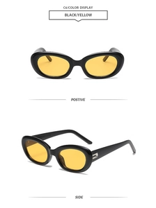 Detail view of oval cat eye sunglasses with black frames and yellow transparent lenses