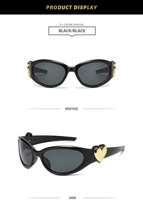 Detail view of black heart sunglasses with golden accents and dark grey lenses