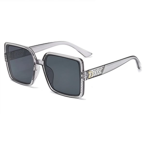 Lunettes de soleil carrées oversize gris transparent avec accents métalliques D dorés