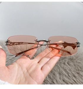 Detailed macro of rimless pink star sunglasses with rose gold metallic temple and stars