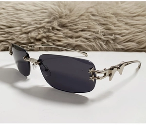 Detail of rimless sunglasses with silver metal butterfly and star accents on the temples