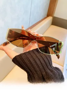 Detail view of large silver metal frame sunglasses with amber lenses and tortoiseshell temples
