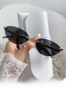 Detail of rimless cat-eye sunglasses with gold metal wave temples and dark purple lenses