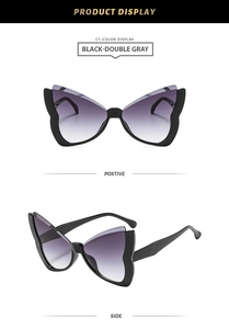 Detail view of butterfly frame sunglasses with black frames and purple gradient lenses