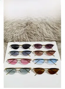 Detail view of cat-eye rimless sunglasses with textured metal top and various lens colors