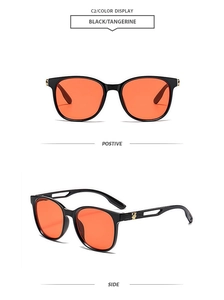 Detail of black sunglasses with tangerine lenses and hollow metal rabbit temples