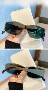 Detail of green lens sunglasses with gold metal frame and tortoiseshell temples