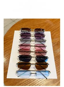Detail view of eight gradient color rimless sunglasses with gold metal studded temples
