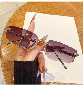 Detail of rimless square sunglasses with purple gradient lenses and wavy metal bridge