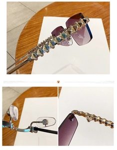Detail view of purple gradient lenses with gold pyramid studs on rimless sunglasses