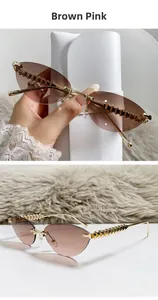 Detail of brown pink cat-eye sunglasses with golden textured metal temples and rimless lens