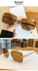 Detail of tea brown rimless sunglasses with textured gold metal temples in a cafe setting