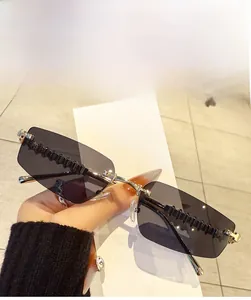 Detailed view of grey rimless sunglasses with jagged decorative lines on the lens