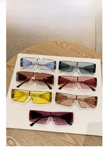 Flat lay display of colorful oversized rimless sunglasses in seven trendy vibrant lens colors