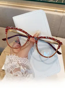 Detailed view of cat-eye frames with red and silver rhinestones and gold metal temples