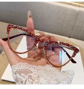 Detail of cat eye glasses frame with red and silver rhinestones on gold metal