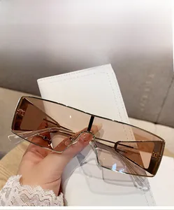 Close-up of light brown lenses and gold metal frame of these oversized square sunglasses