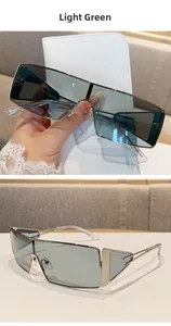 Detail of light green retro square sunglasses with silver geometric hollowed frames