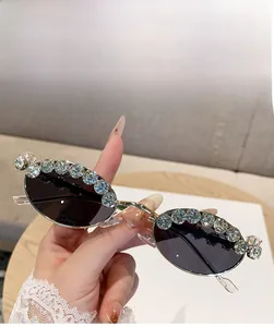 Close-up of golden oval sunglasses featuring luxury large crystal diamond embellishments