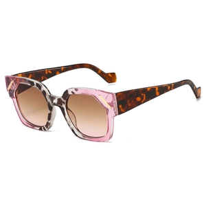Modern hexagonal sunglasses with translucent pink and tortoise shell frame on white