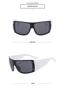 Detail view of oversized one-piece sunglasses in black and white two-tone contrast