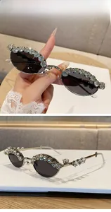 Detailed view of silver oval sunglasses with crystal rhinestones and grey lenses