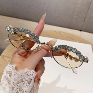 Trendy oval sunglasses with gold frame and blue rhinestones for a stylish aesthetic