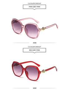 Detail view of pink and red oversized sunglasses frames with golden rose accents