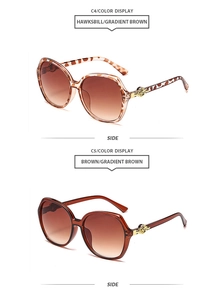 Detail view of tortoiseshell and brown gradient sunglasses with gold circular metal hinges