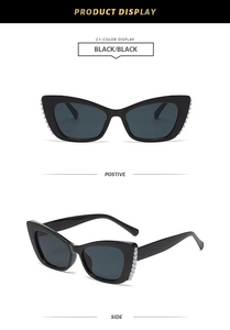 Detail of black cat-eye sunglasses featuring elegant white pearl embellishments on the frame