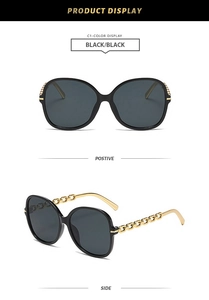 Détails de lunettes de soleil noires avec branche en chaîne dorée et verres teintés gris