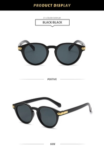 Detail of round retro sunglasses in black finish with gold hinges and dark lenses