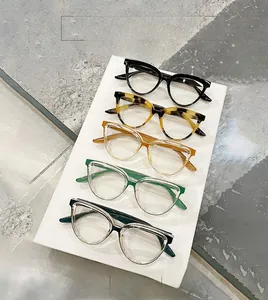 Top view of five stylish cat-eye glasses frames in assorted colors on a neutral surface